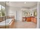 Bathroom features a jacuzzi tub, tiled floor and walls, vanity and a scenic view through the window at 13325 W 86Th Dr, Arvada, CO 80005