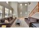 Spacious living room with soaring ceilings, large windows, wood floors and a carpeted seating area at 13325 W 86Th Dr, Arvada, CO 80005