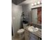 Bathroom with granite countertop, shelving, toilet, and decorative mirror at 7495 E Quincy Ave # 205, Denver, CO 80237