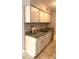 Classic kitchen featuring granite countertops, stainless sink, and white cabinets at 7495 E Quincy Ave # 205, Denver, CO 80237