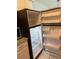 Open refrigerator, granite countertops, microwave and white cabinets at 7495 E Quincy Ave # 205, Denver, CO 80237