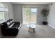 Spacious living room with large windows and sliding door leading to a balcony at 7495 E Quincy Ave # 205, Denver, CO 80237