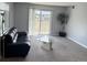 Inviting living room features a comfy black sofa and sliding door to a balcony at 7495 E Quincy Ave # 205, Denver, CO 80237