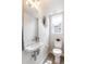 This half bathroom features modern fixtures, a wall mounted sink, and stylish decor at 3449 W 63Rd Pl, Denver, CO 80221
