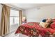 Cozy bedroom features soft carpet, natural light, and a patterned comforter at 3449 W 63Rd Pl, Denver, CO 80221