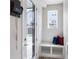 Bright entryway features a window seat with colorful pillows, a mail holder, and a glass front door at 3449 W 63Rd Pl, Denver, CO 80221