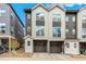 Modern townhome exterior with gray and white siding, attached garages and a well-kept lawn at 3449 W 63Rd Pl, Denver, CO 80221