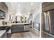 Modern open concept living area with a stylish kitchen, dining area, living room, and stainless appliances at 3449 W 63Rd Pl, Denver, CO 80221