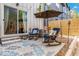 Relaxing outdoor patio with comfortable rocking chairs, umbrella, and privacy fence at 3449 W 63Rd Pl, Denver, CO 80221