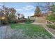 Backyard with a well-manicured lawn, mature trees, and wooden fencing at 12642 E Ohio Ave, Aurora, CO 80012