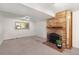 Basement room featuring a brick fireplace, neutral carpet, and bright lighting at 12642 E Ohio Ave, Aurora, CO 80012