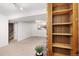 A finished basement area with a brick fireplace and adjacent shelving, offering a cozy and versatile space at 12642 E Ohio Ave, Aurora, CO 80012