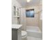 A bathroom with a tiled shower featuring a patterned shower curtain, and a wall-mounted storage cabinet at 12642 E Ohio Ave, Aurora, CO 80012