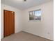 Bright bedroom featuring carpet flooring, window, and a bifold door at 12642 E Ohio Ave, Aurora, CO 80012