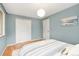 Bright bedroom featuring hardwood floors, closet space, and natural light from a window with a decorative lamp at 12642 E Ohio Ave, Aurora, CO 80012