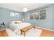 Light and airy bedroom with an abundance of natural light, wood floors, and a cozy accent bench at 12642 E Ohio Ave, Aurora, CO 80012