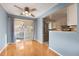 Bright dining room featuring hardwood floors, access to a balcony, and seamless flow to the kitchen at 12642 E Ohio Ave, Aurora, CO 80012