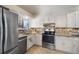 Bright kitchen featuring stainless steel appliances, granite counters, and tile backsplash at 12642 E Ohio Ave, Aurora, CO 80012