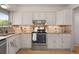 Well-lit kitchen features white cabinets, granite countertops, and a stylish tile backsplash at 12642 E Ohio Ave, Aurora, CO 80012