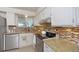 Modern kitchen features white cabinets, granite countertops, and stainless steel appliances at 12642 E Ohio Ave, Aurora, CO 80012