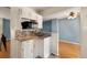 This kitchen features granite counters, mosaic tile backsplash and white cabinets at 12642 E Ohio Ave, Aurora, CO 80012