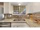Kitchen sink with granite countertops, tile backsplash, and a bright window view at 12642 E Ohio Ave, Aurora, CO 80012