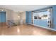Bright living room with wood floors, large windows, and updated railing to the second floor at 12642 E Ohio Ave, Aurora, CO 80012
