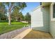 Back patio with gravel area, grassy backyard, and a view of surrounding trees at 9202 W Ontario Dr, Littleton, CO 80128
