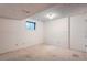 Empty basement room with paneled walls, neutral carpet, and natural light from a window at 9202 W Ontario Dr, Littleton, CO 80128