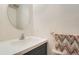 Powder bathroom features a modern vanity with oval mirror, perfect for guests at 9202 W Ontario Dr, Littleton, CO 80128