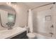 Updated bathroom features a modern vanity, shower and bathtub with white marble tiling at 9202 W Ontario Dr, Littleton, CO 80128