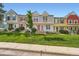 The row of townhomes showcases lovely curb appeal and is enhanced by a lush green lawn at 9202 W Ontario Dr, Littleton, CO 80128
