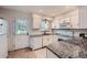Bright kitchen with granite countertops, white cabinets, and modern appliances at 9202 W Ontario Dr, Littleton, CO 80128