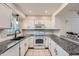 Updated kitchen with white cabinets, granite countertops, and modern hardware fixtures at 9202 W Ontario Dr, Littleton, CO 80128