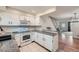 Well-lit kitchen features white cabinets, granite countertops, and a view into the living room at 9202 W Ontario Dr, Littleton, CO 80128