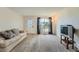 Bright living room features neutral carpet, a large window, and a cozy sofa at 9202 W Ontario Dr, Littleton, CO 80128