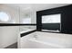 Modern bathroom with a soaking tub, glass-enclosed shower, and stylish black and white tile accents at 14712 Kalamath Ct, Westminster, CO 80023
