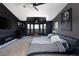 Modern bedroom with dark walls, a stylish bed, a seating area, and an eye-catching light fixture for luxury comfort at 14712 Kalamath Ct, Westminster, CO 80023