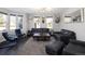 Spacious living room with three windows, dark wood floors, and stylish leather furniture at 14712 Kalamath Ct, Westminster, CO 80023