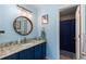 Updated bathroom features blue cabinets and granite countertops at 19437 E Mann Creek Dr # A, Parker, CO 80134