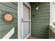 Close up of a green home's front door with a stylish decorative sun accent and modern doorbell at 19437 E Mann Creek Dr # A, Parker, CO 80134