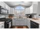 Updated kitchen featuring white cabinets, stainless steel appliances, and modern fixtures at 19437 E Mann Creek Dr # A, Parker, CO 80134
