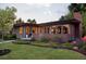 A beautiful home with a brick chimney, a well manicured lawn, lovely flowers, and mature trees at 8955 E 19Th Ave, Aurora, CO 80010
