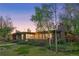 Charming home exterior with expansive windows and lush landscaping at dusk at 8955 E 19Th Ave, Aurora, CO 80010