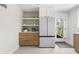 Modern kitchenette features a refrigerator, wood cabinets, and shelves with décor at 8955 E 19Th Ave, Aurora, CO 80010