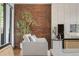 Bright living room featuring a brick accent wall, neutral-toned sofa, and modern decor for a stylish and comfortable living space at 8955 E 19Th Ave, Aurora, CO 80010