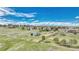 Expansive land with a barn, fenced pastures, and scattered homes under a bright sky with scattered clouds at 2188 Savage Rd, Elizabeth, CO 80107
