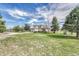 Landscaped front yard showcasing a well-maintained lawn, mature trees, and a charming residence at 2188 Savage Rd, Elizabeth, CO 80107