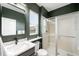 Modern bathroom features dark green walls, updated vanity, and a glass-enclosed shower at 10906 Pastel Pt, Parker, CO 80134