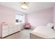 Cozy pink bedroom featuring a white dresser, plush chair, and a twin bed at 10906 Pastel Pt, Parker, CO 80134